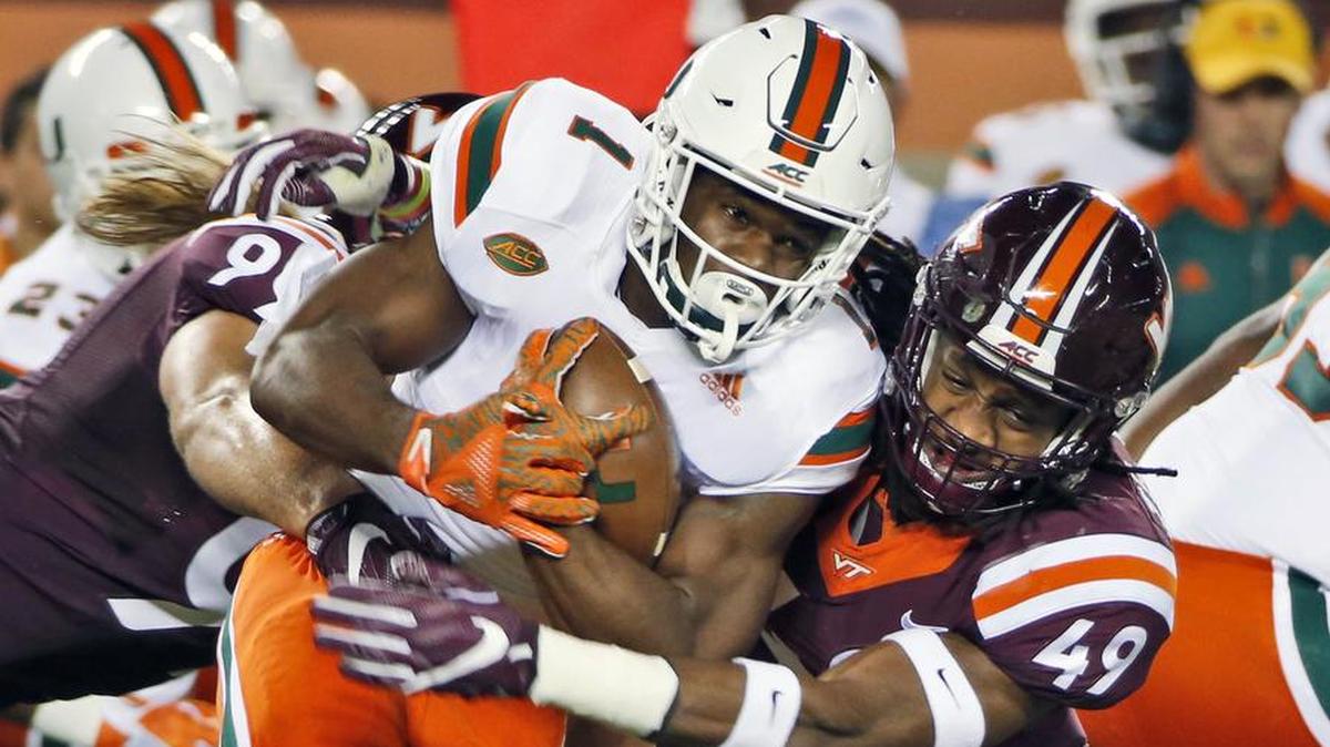 Miami running back Mark Walton (1) tries to get past Virginia Tech linebacker Tremaine Edmunds (49) and defensive lineman Vinny Mihota, left, during the first half of an NCAA college football game in October 2016. Edmunds is a possibility for the Dolphins' pick at 11.