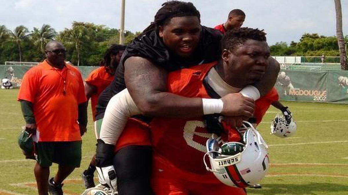 
After UM’s final practice before the spring game, 6-8, 322-pound offensive tackle Sunny Odogwu carries 6-4, 325-pound senior defensive tackle Mike Wyche off the field Thursday, March 26, 2015 as part of a tradition. 
