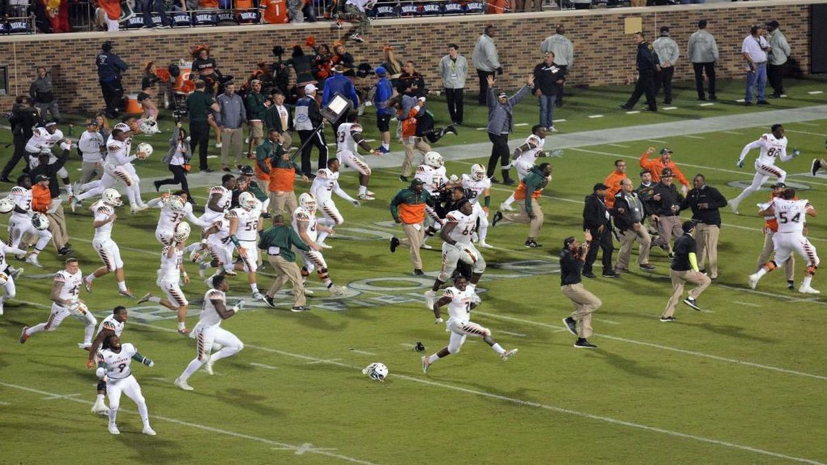 Miami players run onto the field to celebrate their 30-27 win over Duke in the final seconds of an NCAA college football game in Durham, N. C.