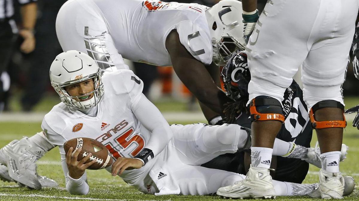 
Miami quarterback Brad Kaaya (15) is sacked by Cincinnati defensive lineman Silverberry Mouhon (92) during the second half of an NCAA college football game, Thursday, Oct. 1, 2015, in Cincinnati. Cincinnati won 34-23. 
