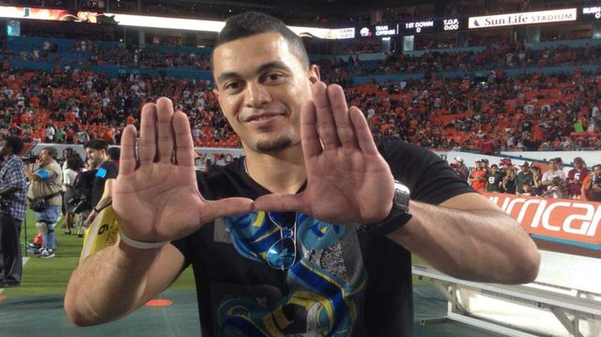 
Supporting the canes: Marlins outfielder Giancarlo Stanton gives the ‘U’ sign while at Saturday’s game. 
