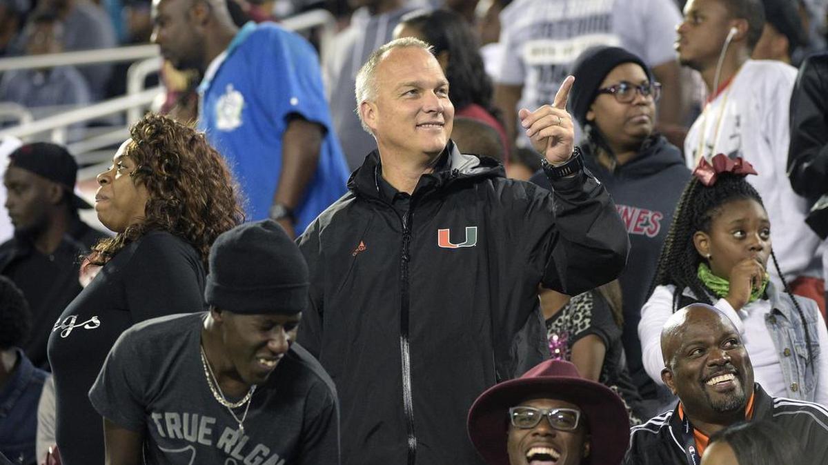 University of Miami head coach Mark Richt, center, watches from the stands during the second half of a high school football championship game between Jacksonville Raines and Booker T. Washington.