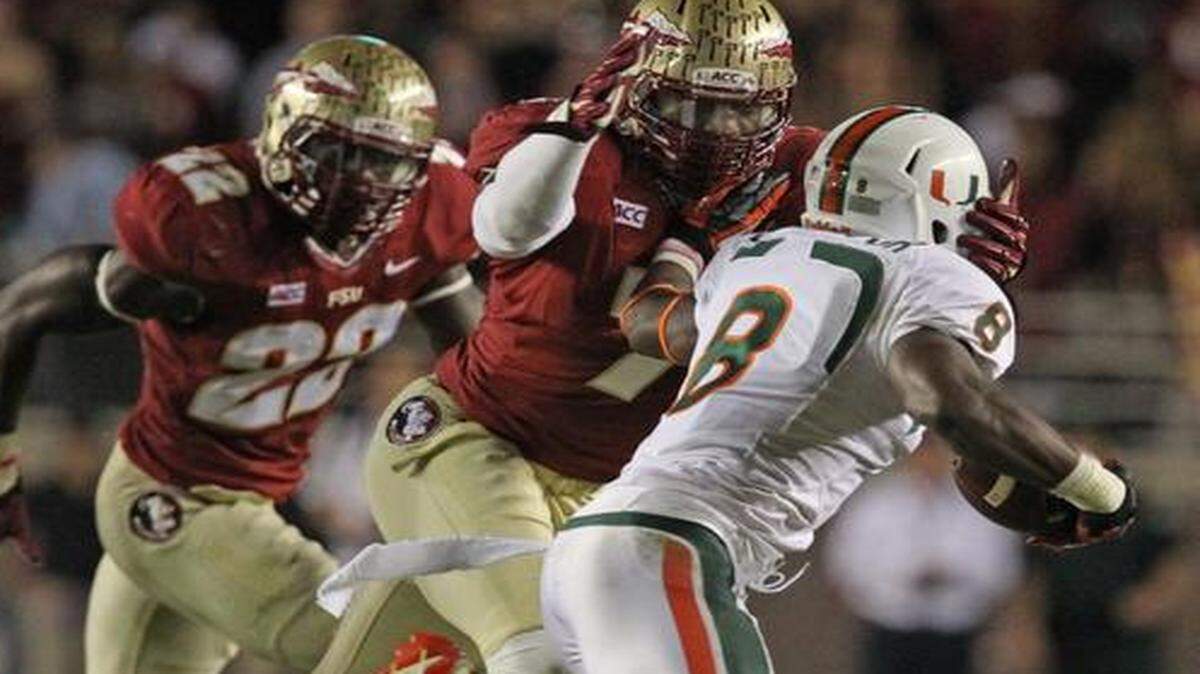 
UM’s Duke Johnson is stopped by FSU’s Christian Jones at Doak Campbell Stadium on Saturday, Nov. 2, 2013.
