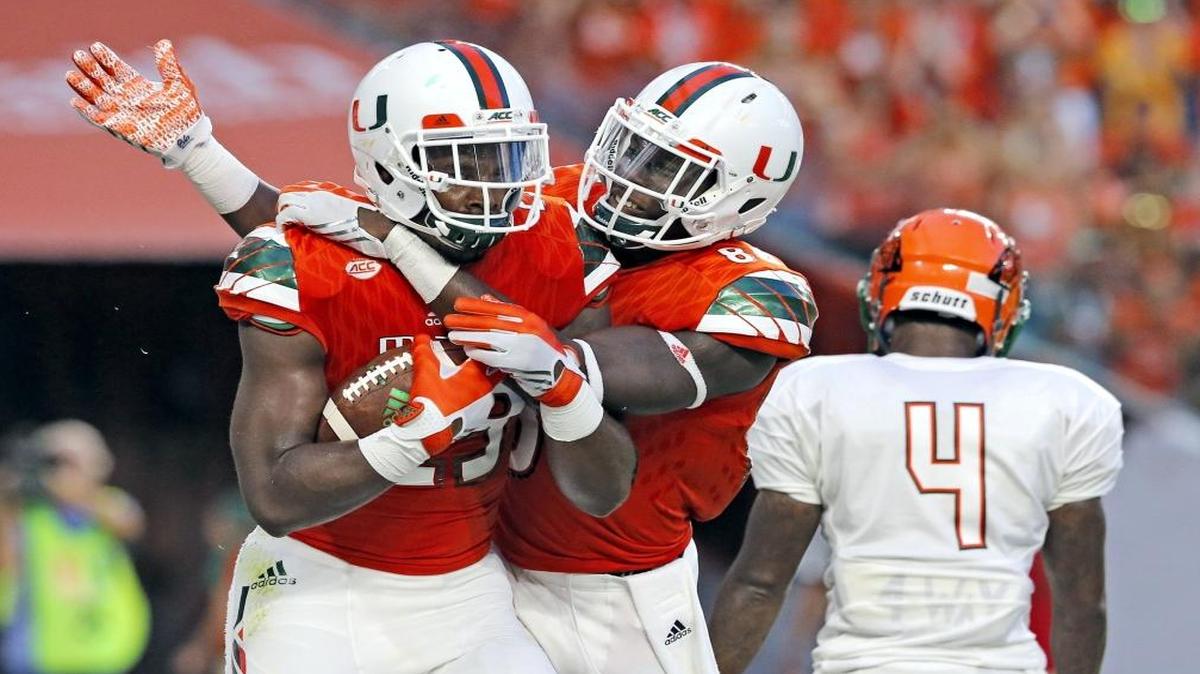 Miami Hurricanes tight end Christopher Herndon (23) and tight end David Njoku (86) celebrate in the endzone after Herndon scores in the second quarter as Florida A&M Rattlers defensive back Jacques Bryant (18) fails to defend as the University of Miami hosts Florida A&M at Hard Rock Stadium on Satur., Sept. 3, 2016.