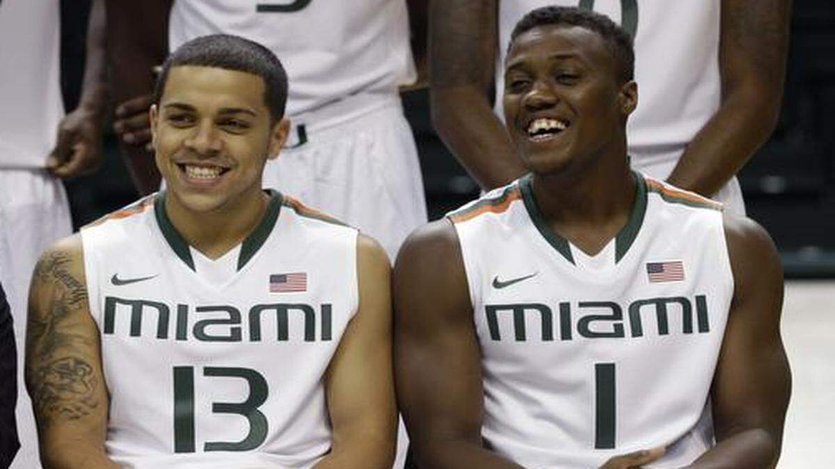
Miami guard Angel Rodriguez (13) sits with guard Deandre Burnett (1) for a team photo during NCAA college basketball media day, Thursday, Oct. 16, 2014, in Coral Gables, Fla. 
