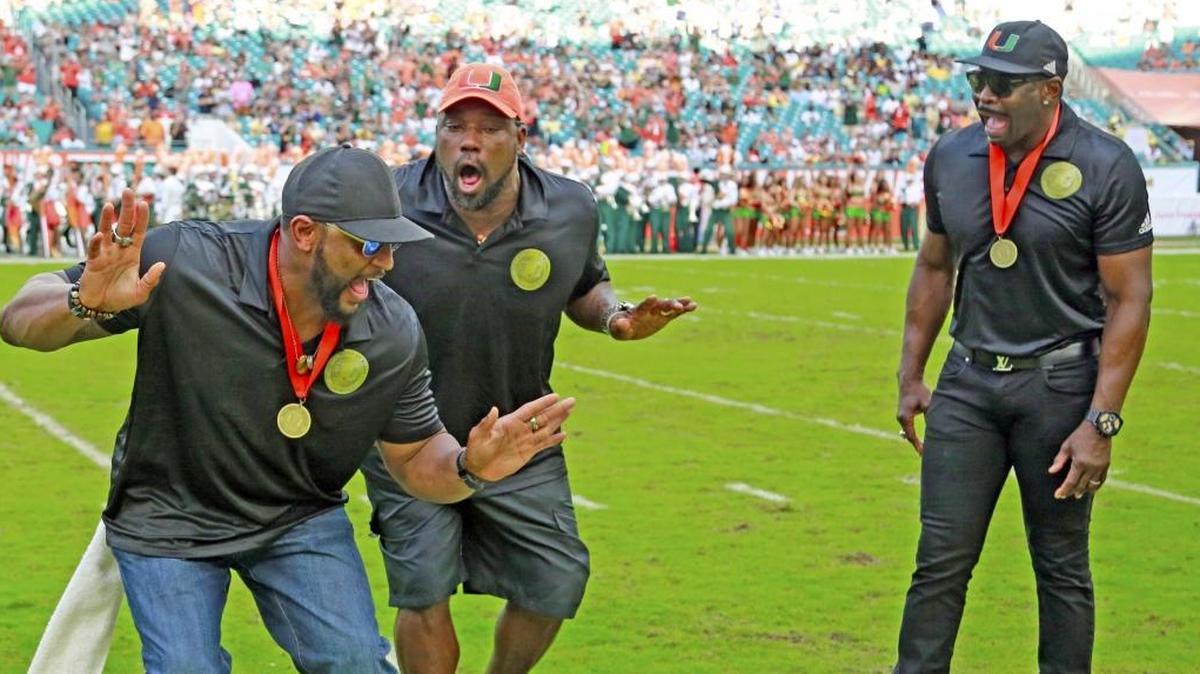From left: Ray Lewis; Warren Sapp and Michael Irvin celebrate being inducted into the UM Ring of Honor during halftime of the Miami-Georgia Tech game.