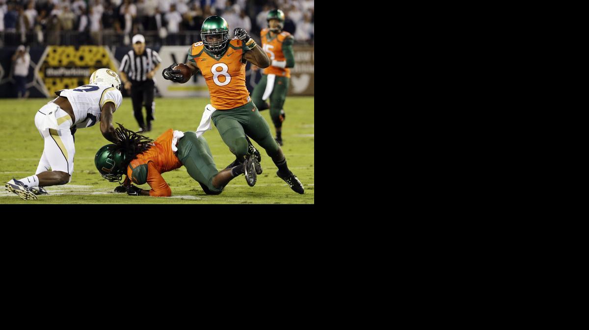 
Miami's Duke Johnson, right, trips over the legs of teammate Malcolm Lewis as he helps block Georgia Tech's Lynn Griffin, left, on a run in the first half of an NCAA college football game, Saturday, Oct. 4, 2014, in Atlanta. Georgia Tech won 28-17. 
