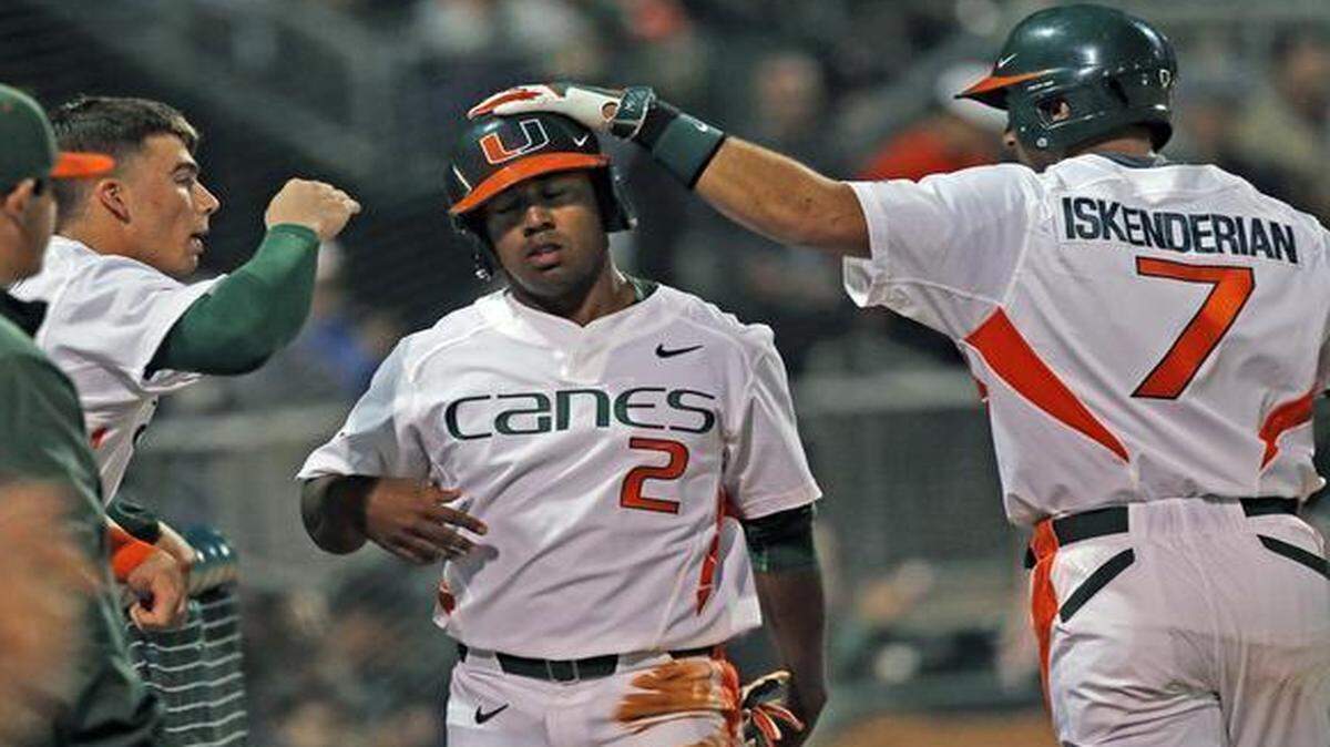 
Ricky Eusebio scores in the first inning on a hit by Willie Abreu as the University of Miami hosts Rutgers at Mark Light Field on Friday, Feb. 13, 2015.
