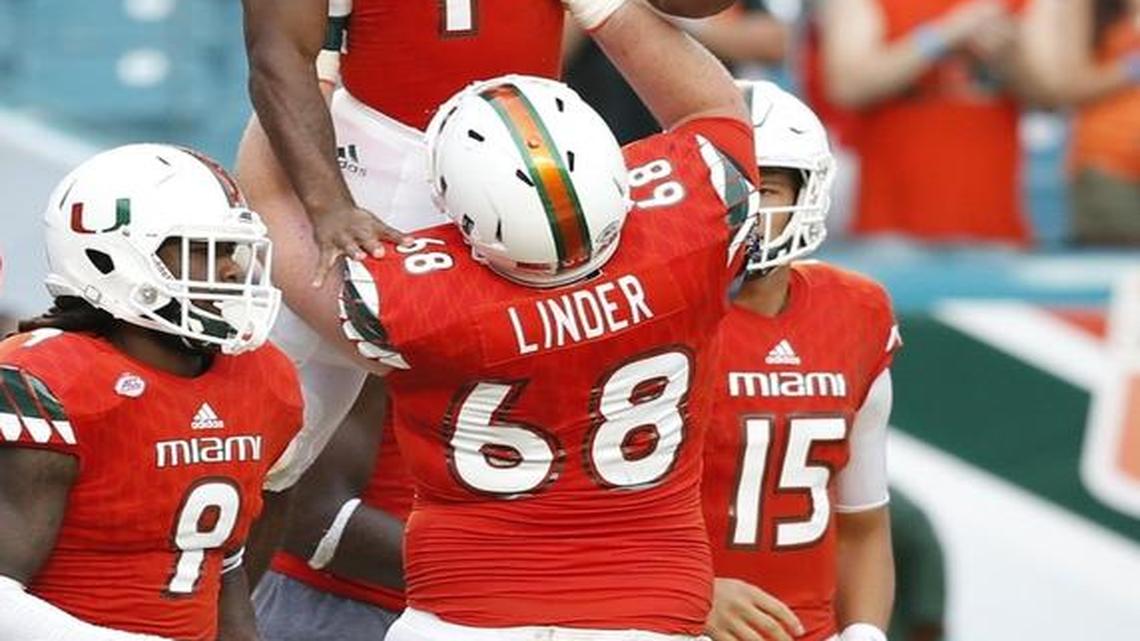 Miami Hurricanes running back Mark Walton (1) celebrates as he is lifted by Miami Hurricanes offensive lineman Nick Linder (68) in the fourth quarter as the University of Miami hosts Georgia Tech at Sun Life Stadium on Sat., Nov. 21, 2015