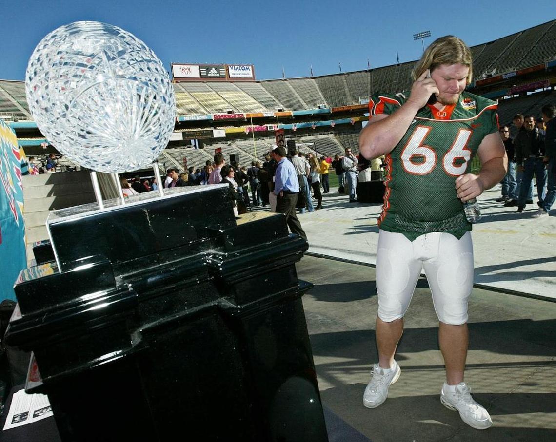 The University of Miami's center Brett Romberg does a radio interview standing by the crystal national Championship trophy during Media Day on Dec. 31, 2002.