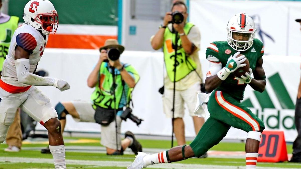 Miami Hurricanes Jeff Thomas (4) catches the ball and runs for a third quarter touchdown as Syracuse University Devin Butler (7) gives chase at Hard Rock Stadium in Miami Gardens, Florida, Oct. 21, 2017.