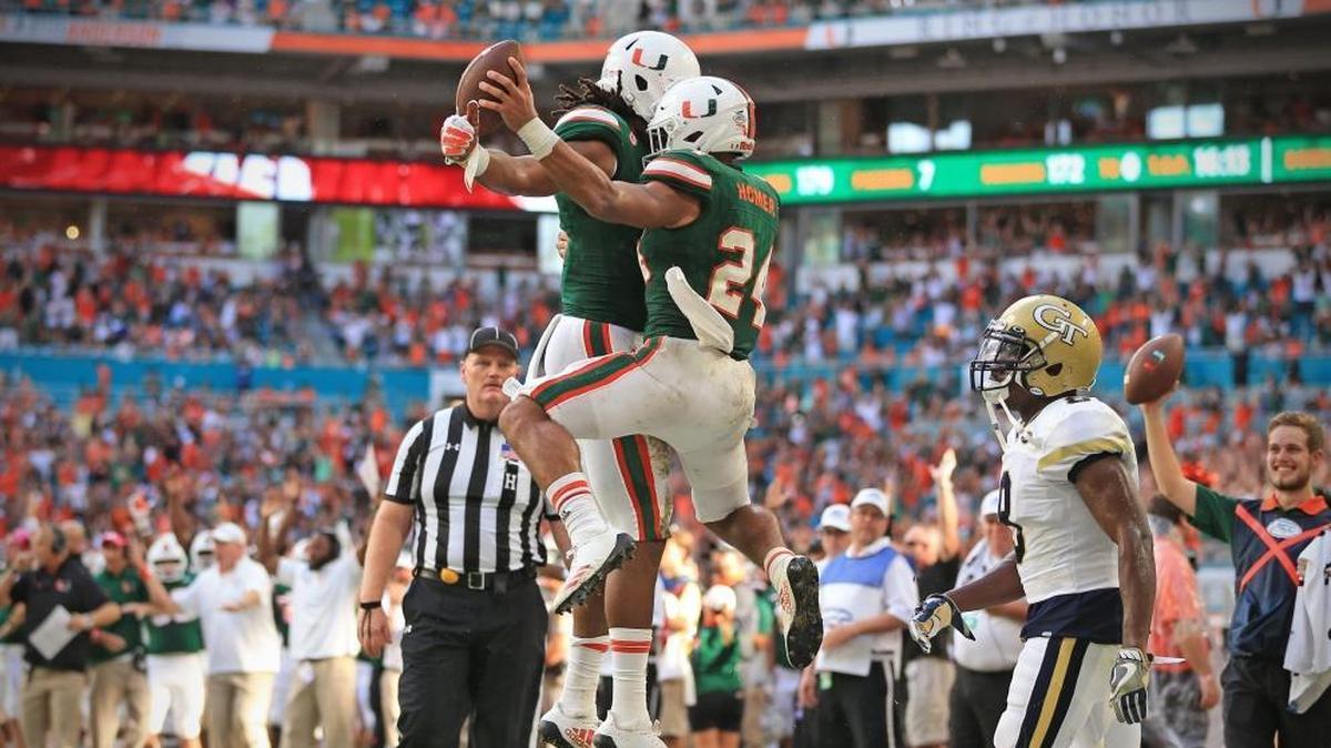 Miami Hurricanes running back Travis Homer and wide receiver Darrell Langham celebrate after Homer scores in the second quarter of the Georgia Tech game at Hard Rock Stadium on Saturday, October 14, 2017.