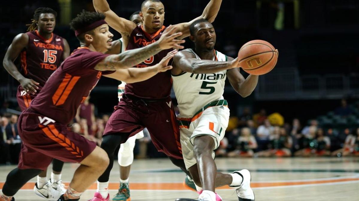 Miami's Davon Reed (5) passes as Virginia Tech's Seth Allen, left, and Justin Robinson, center, defend during the second half of an NCAA basketball game, Wed., Feb. 8, 2017, in Coral Gables, Fla. Miami defeated Virginia Tech 74-68.
