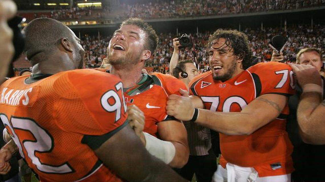
University of Miami quarterback Brock Berlin, center, celebrates with Orien Harris, left, and Joel Rodriguez, right, at midfield of the Orange Bowl after defeating the Florida State Seminoles on Sept. 10, 2004.
