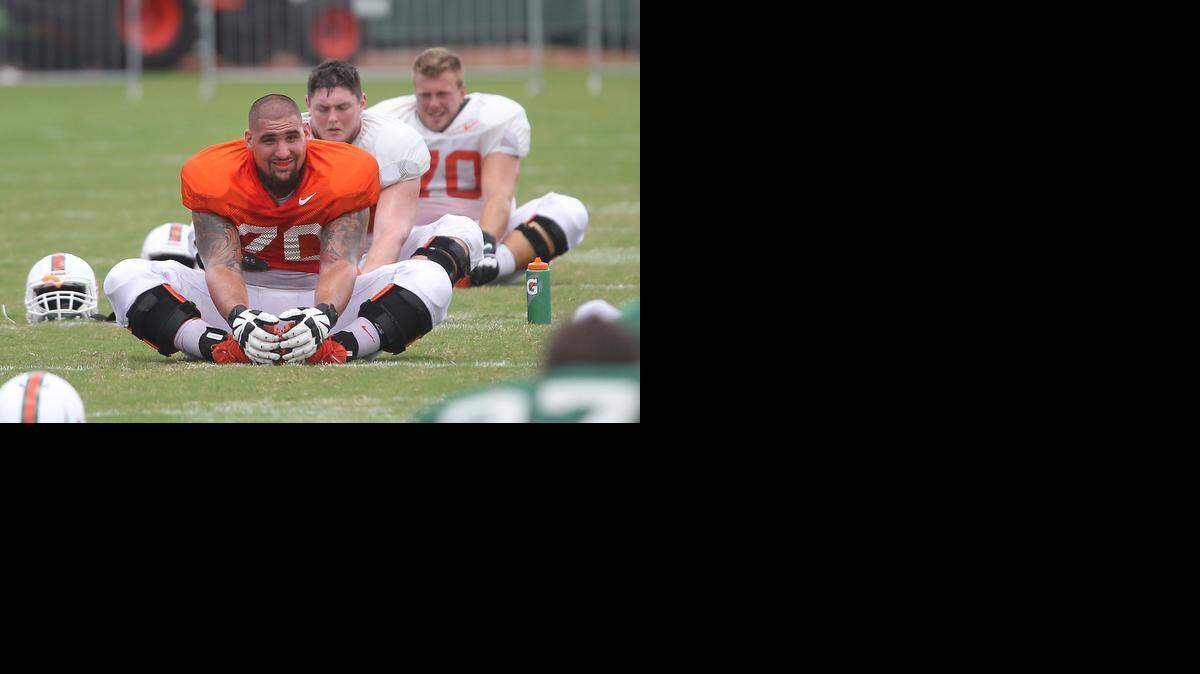 Offensive lineman Jon Feliciano stretches as the University of Miami practices on Sunday, August 24, 2014.

