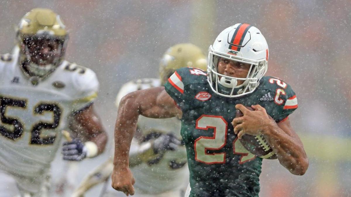 Miami Hurricanes running back Travis Homer (24) runs towards the end zone in torrential rain to score in the fourth quarter against Georgia Tech at Hard Rock Stadium on Saturday, October 14, 2017.