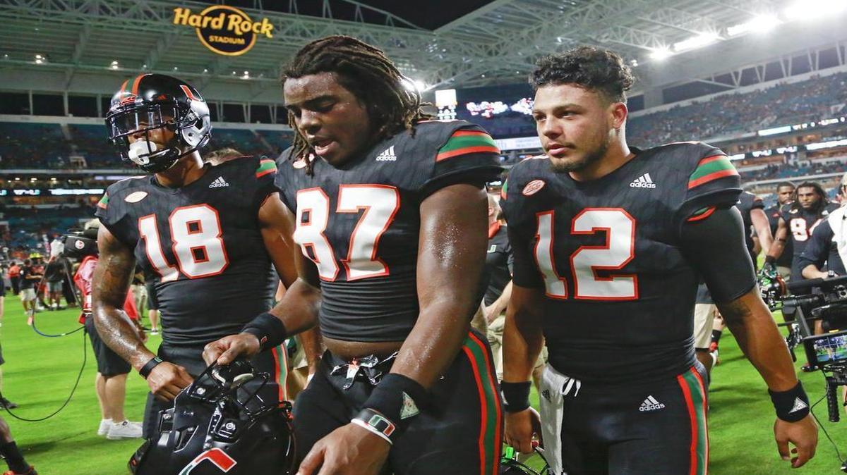 Miami Hurricanes tight end Michael Irvin II (87) is flanked by receiver Lawrence Cager (18) and quarterback Malik Rosier after UM defeated Virginia Tech at Hard Rock Stadium on Sat., Nov. 4, 2017.