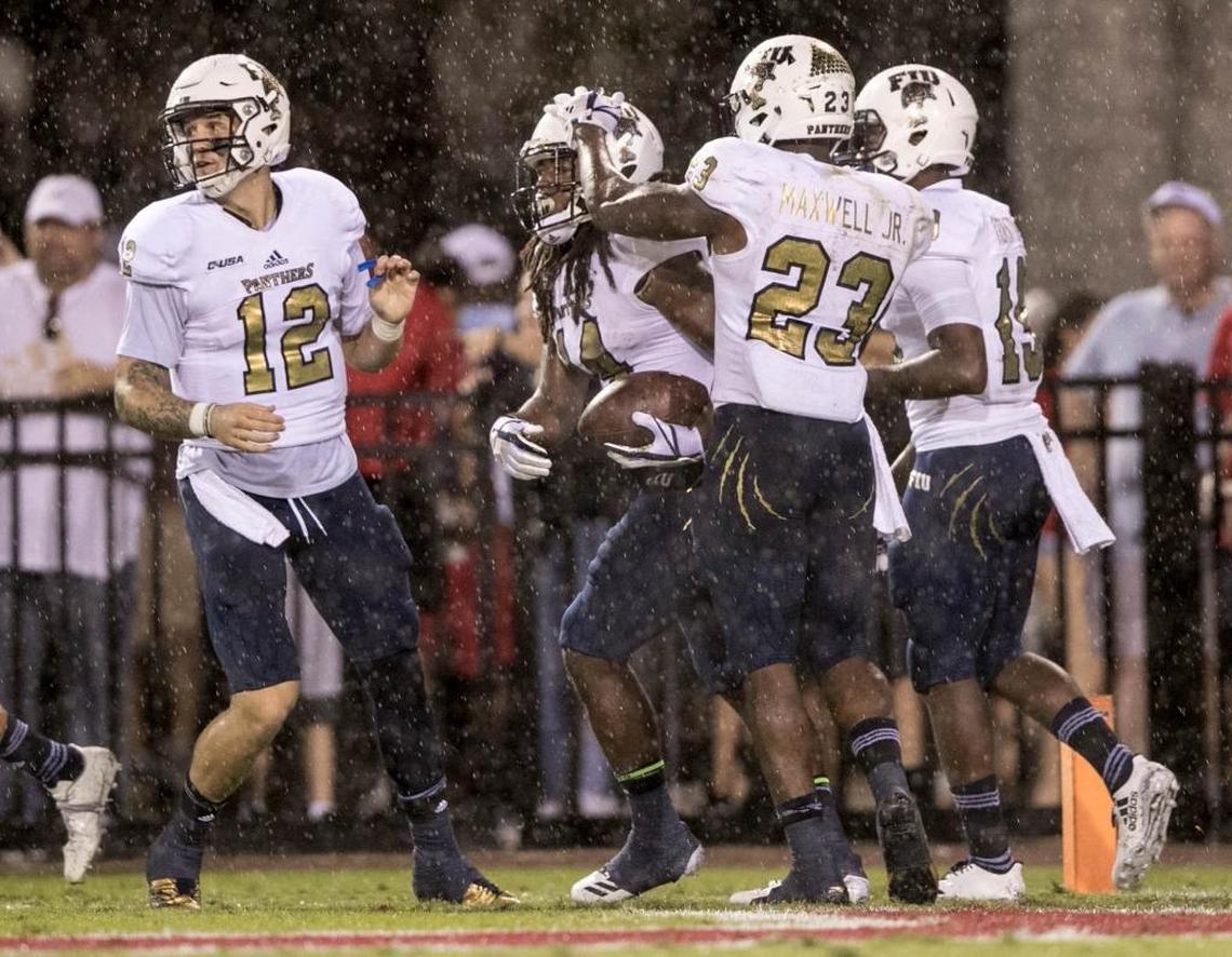 FIU wide receiver Darrius Scott (14) is congratulated by quarterback Alex McGough (12), running back Napoleon Maxwell (23) and wide receiver Shermar Thornton (19) after Scott’s touchdown against Florida Atlantic Saturday.