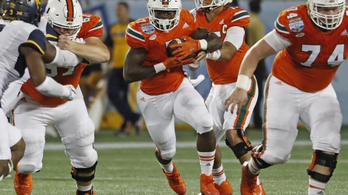 Miami Hurricanes quarterback Brad Kaaya (15) hands off to running back Gus Edwards (7) in the second quarter as the University of Miami takes on the West Virginia Mountaineers at the Russell Athletic Bowl in Orlando Wed., Dec. 28, 2016.