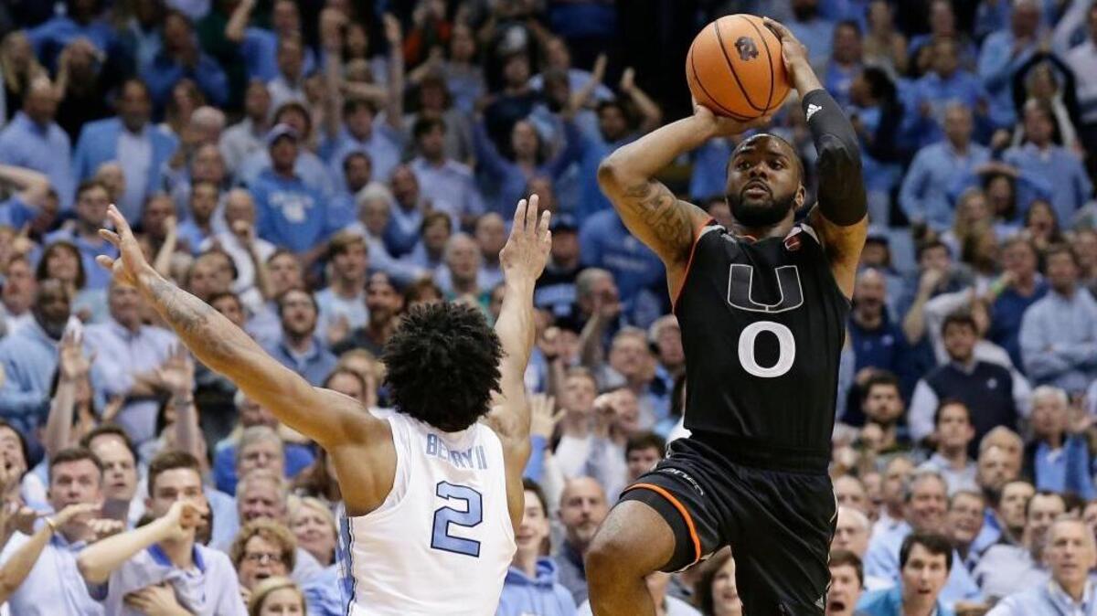 Miami's Ja'Quan Newton (0) shoots the game-winning shot as time expires while North Carolina's Joel Berry II (2) defends during the second half of an NCAA college basketball game in Chapel Hill, N.C., Tuesday, Feb. 27, 2018. Miami won 91-88.