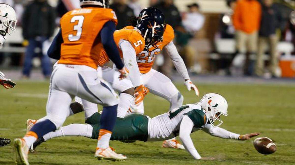 
UM kicker Michael Badgley dives for a blocked field-goal attempt as Virginia’s Quin Blanding (3) and Maurice Canady (26) close in.
