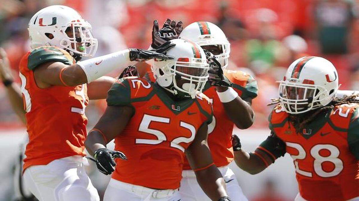 
Miami Hurricanes linebacker Denzel Perryman (52) celebrates a big hit with teammates in the first quarter as the University of Miami hosts Cincinnati at Sun Life Stadium on Saturday, October 11, 2014.
