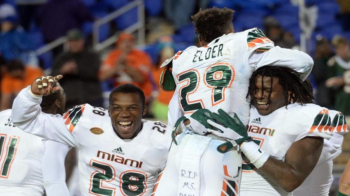 UM’s Corn Elder (29) jumps into the arms of teammate Stan Dobard after Elder scored the winning touchdown.