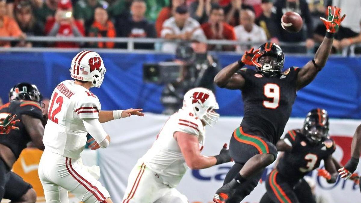 Miami Hurricanes’ Chad Thomas (9) tries to block Wisconsin Badgers quarterback Alex Hornibrook's (12) pass in the first quarter in the 2017 Capital One Orange Bowl at Hard Rock Stadium in Miami Gardens on December 30, 2017.