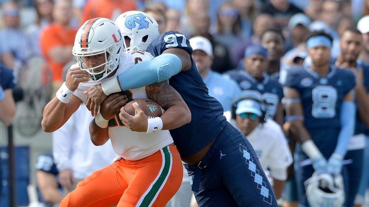 North Carolina Tar Heels Jalen Dalton (97) tackles Miami Hurricanes Malik Rosier (12) during their game at Kenan Stadium on October 28, 2017 in Chapel Hill, North Carolina.