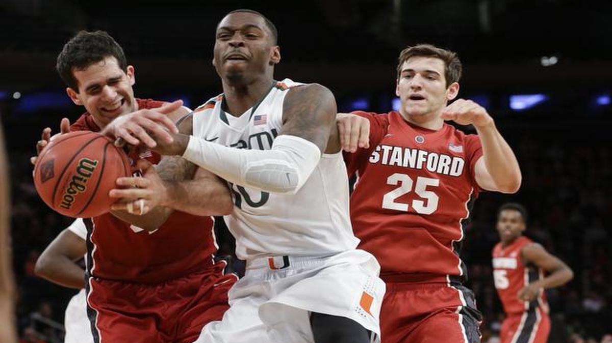 
Miami's Sheldon McClellan, center, fights for control of the ball with Stanford's Stefan Nastic, left, and Rosco Allen, right, during the first half of the championship game of the NIT college basketball tournament Thursday, April 2, 2015, in New York. 
