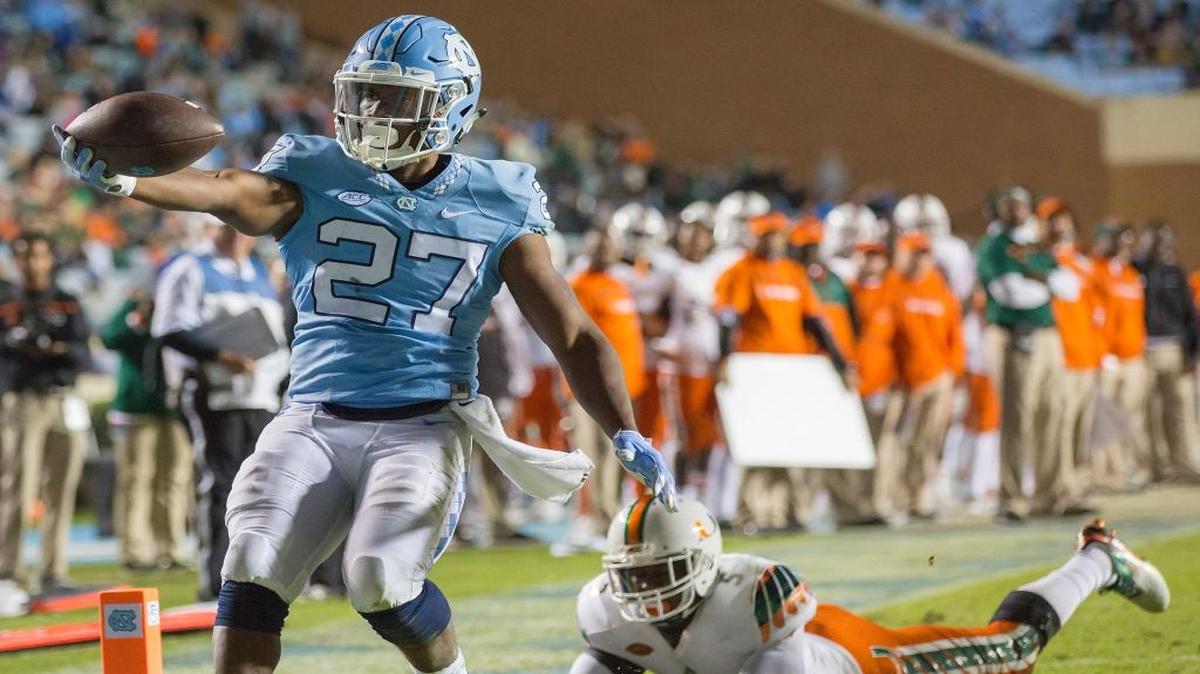 North Carolina's Charles Brunson scores a touchdown in front of Miami's Jermaine Grace during the second half of an NCAA college football game, in Chapel Hill, N.C., Saturday, Nov. 14, 2015.