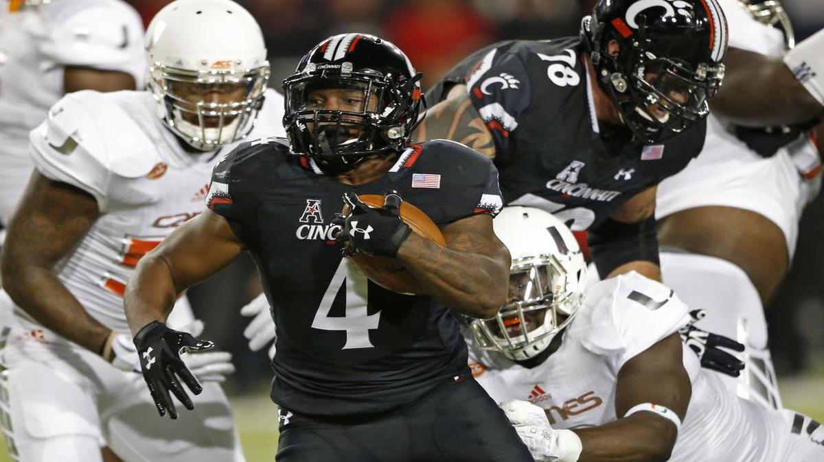
Cincinnati running back Hosey Williams (4) breaks a tackle by Miami defensive lineman Chad Thomas (9), right, for a touchdown during the first half of an NCAA college football game, Thursday, Oct. 1, 2015, in Cincinnati. 

