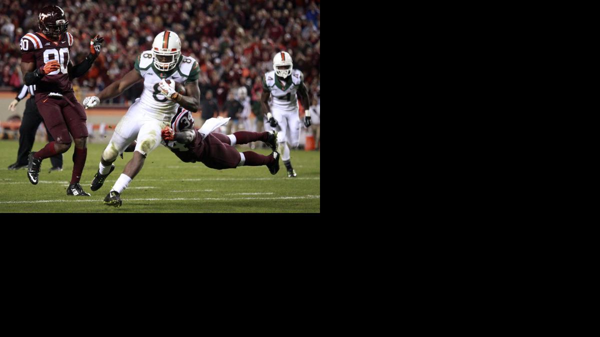 
Miami's Duke Johnson (8) scores a second-quarter touchdown after escaping a tackle attempt of Virginia Tech's Kyshoen Jarrett (34) as defensive end Dadi Nicolas, left, watches during an NCAA college football game in Blacksburg, Va.,Thursday, Oct. 23 2014. 
