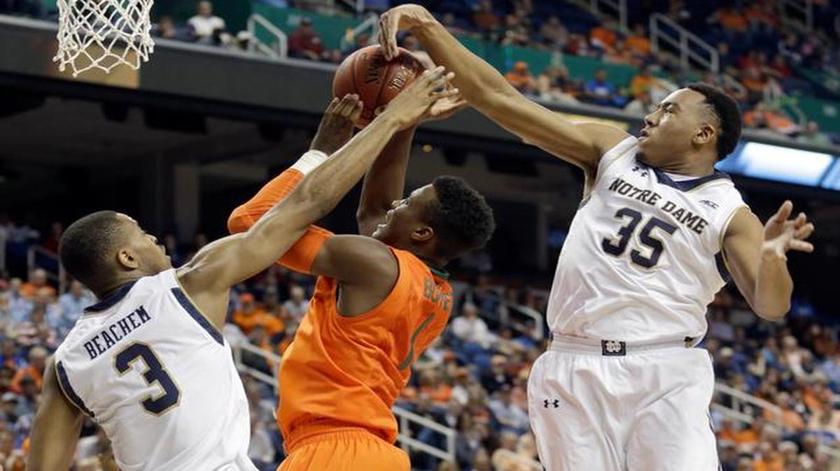 
Miami's Deandre Burnett (1) has his shot blocked as he drives between Notre Dame's V.J. Beachem (3) and Bonzie Colson (35) during the first half of an NCAA college basketball game in the quarterfinals of the Atlantic Coast Conference tournament in Greensboro, N.C., Thursday, March 12, 2015.
