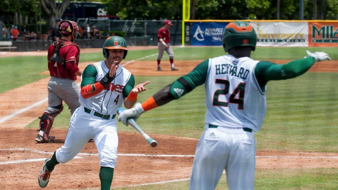 Miami Hurricanes infielder John Ruiz (4) celebrates with his teammate Miami Hurricanes outfielder Jacob Heyward (24) after crossing home plate for the first run of the game during their game against Boston College in game 3 of the NCAA Super Regionals held at Mark Light Field on June 12, 2016.