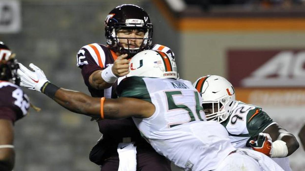 
Quarterback Michael Brewer #12 of the Virginia Tech Hokies is hit by linebacker Raphael Kirby #56 of the Miami Hurricanes after he throws the ball in the first half at Lane Stadium on October 23, 2014 in Blacksburg, Virginia.
