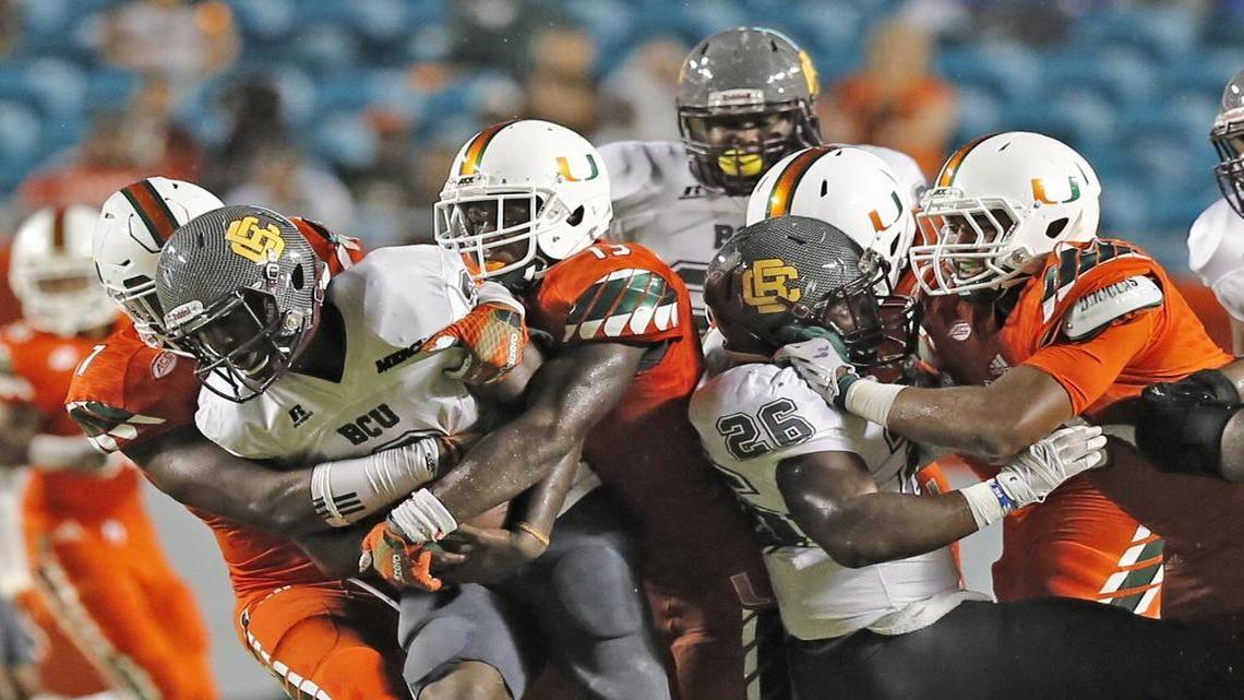 Miami Hurricanes linebacker Tyriq McCord (17) and linebacker Marques Gayot (13) sack Bethune-Cookman Wildcats quarterback Quentin Williams at Sun Life Stadium on Saturday, September 5, 2015.