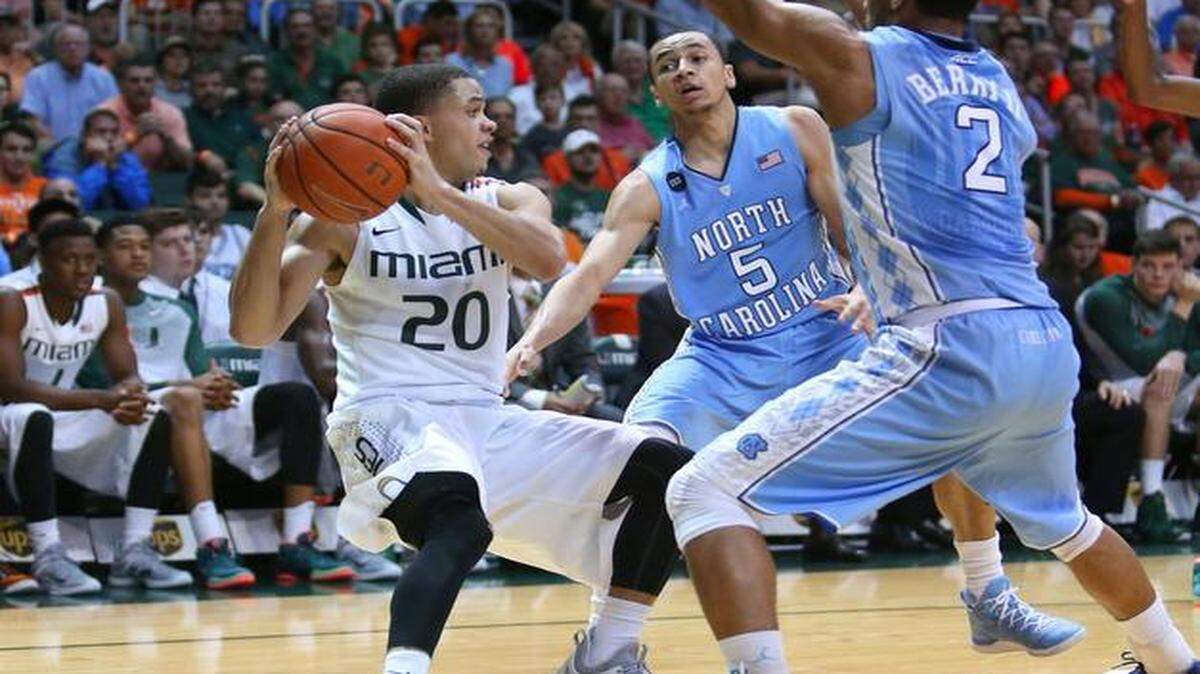 
UM guard Manu Lecomte (20) looks to pass against North Carolina’s Marcus Paige (5) and Joel Berry II during Saturday’s game, which Lecomte started for the ailing Angel Rodriguez.
