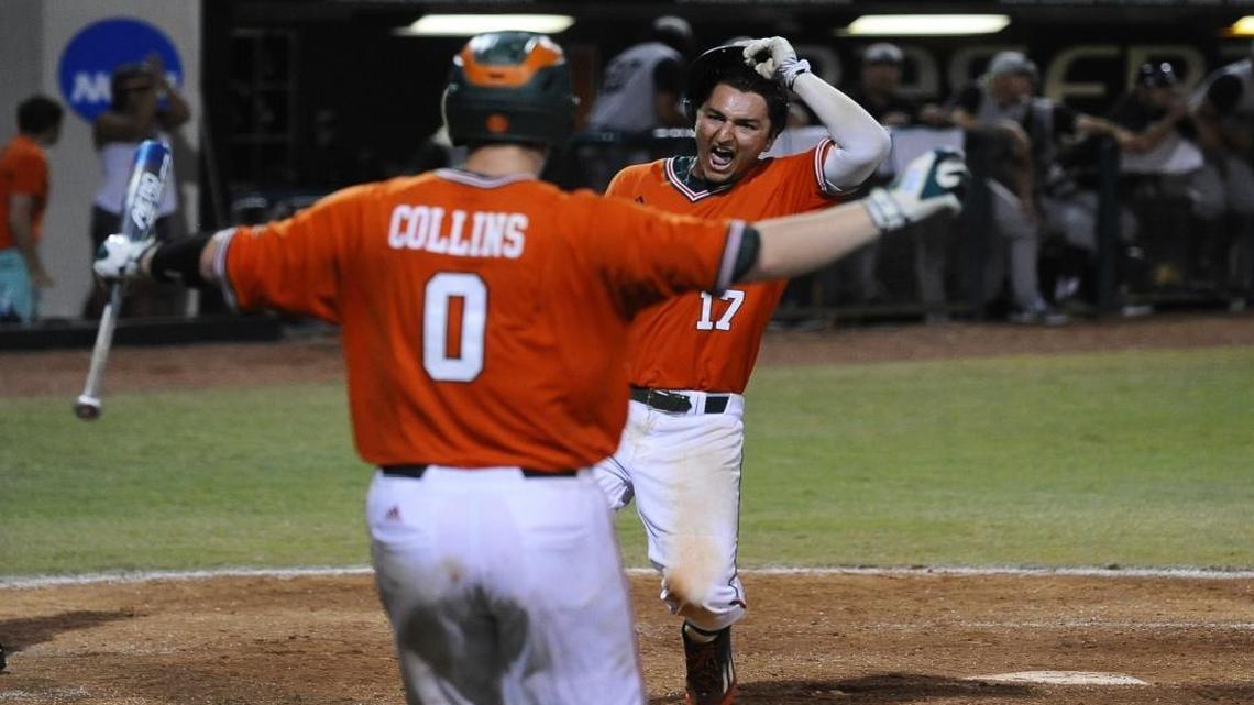 First baseman Christopher Barr of the Miami Hurricanes celebrates after touching home plate to score the game-winning run as Zack Collins awaits him during the NCAA Baseball Championship Coral Gables Regional finals game against Long Beach State University on Sun., June 5, 2016, held at Mark Light Field.