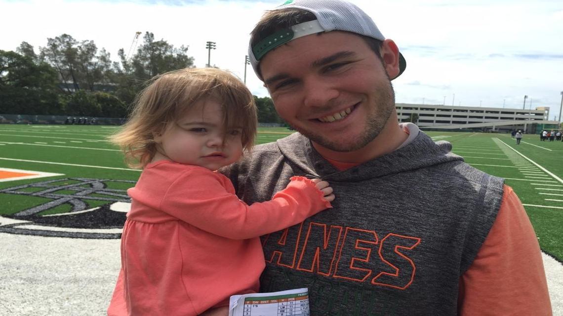 University of Miami quarterbacks coach Jon Richt, son of head coach Mark Richt, with daughter Jadyn, after practice Tuesday, March 22, 2016.