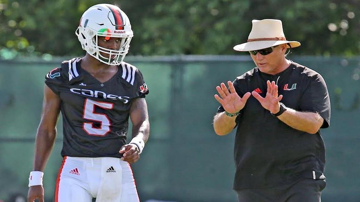 UM true freshman quarterback N’Kosi Perry (5) is instructed by Hurricanes coach Mark Richt during his first practice on the opening day of 2017 fall football camp.