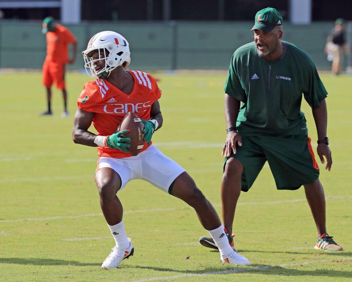 Wide receivers coach Ron Dugans with Jeff Thomas (4) as the University of Miami opens fall football camp at Greentree Field on Tuesday, Aug. 1, 2017.