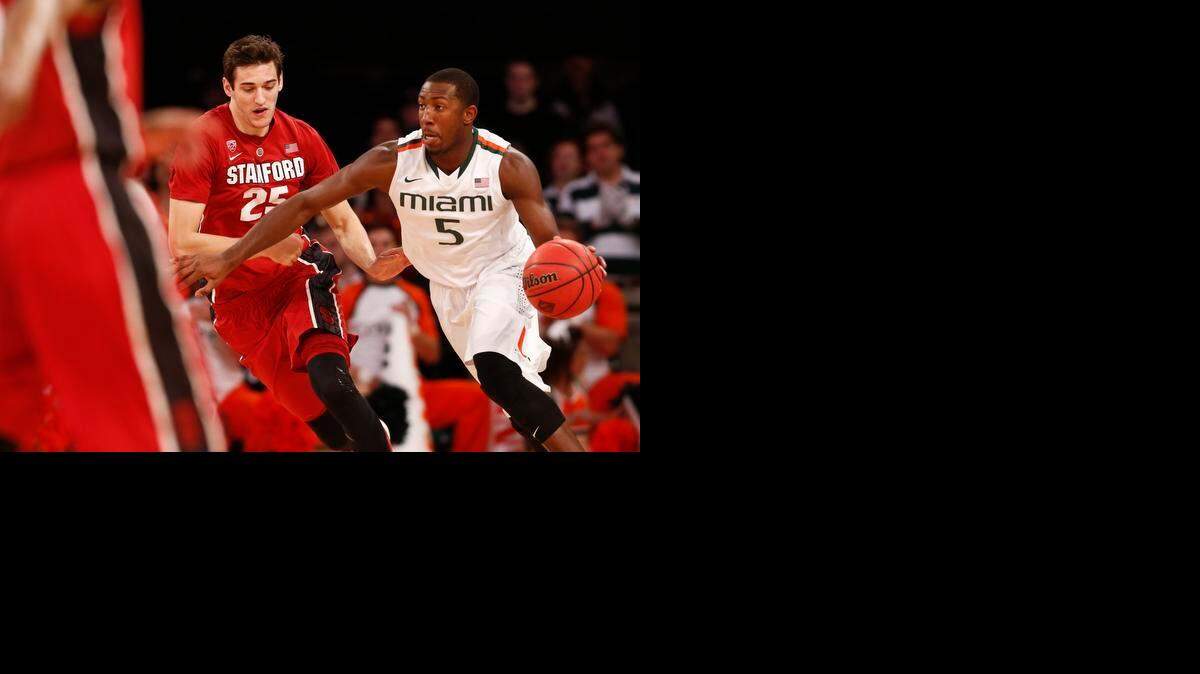 
 Davon Reed #5 of the Miami Hurricanes drives by Rosco Allen #25 of the Stanford Cardinal during the NIT Championship at Madison Square Garden on April 2, 2015 in New York City. 
