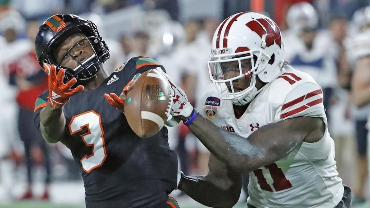 Wisconsin Badgers cornerback Nick Nelson (11) deflects a pass intended for Miami Hurricanes wide receiver Mike Harley (3) in the fourth quarter as the University of Miami takes on the Wisconsin Badgers in the Capital One Orange Bowl at Hard Rock Stadium on Saturday, December 30, 2017.