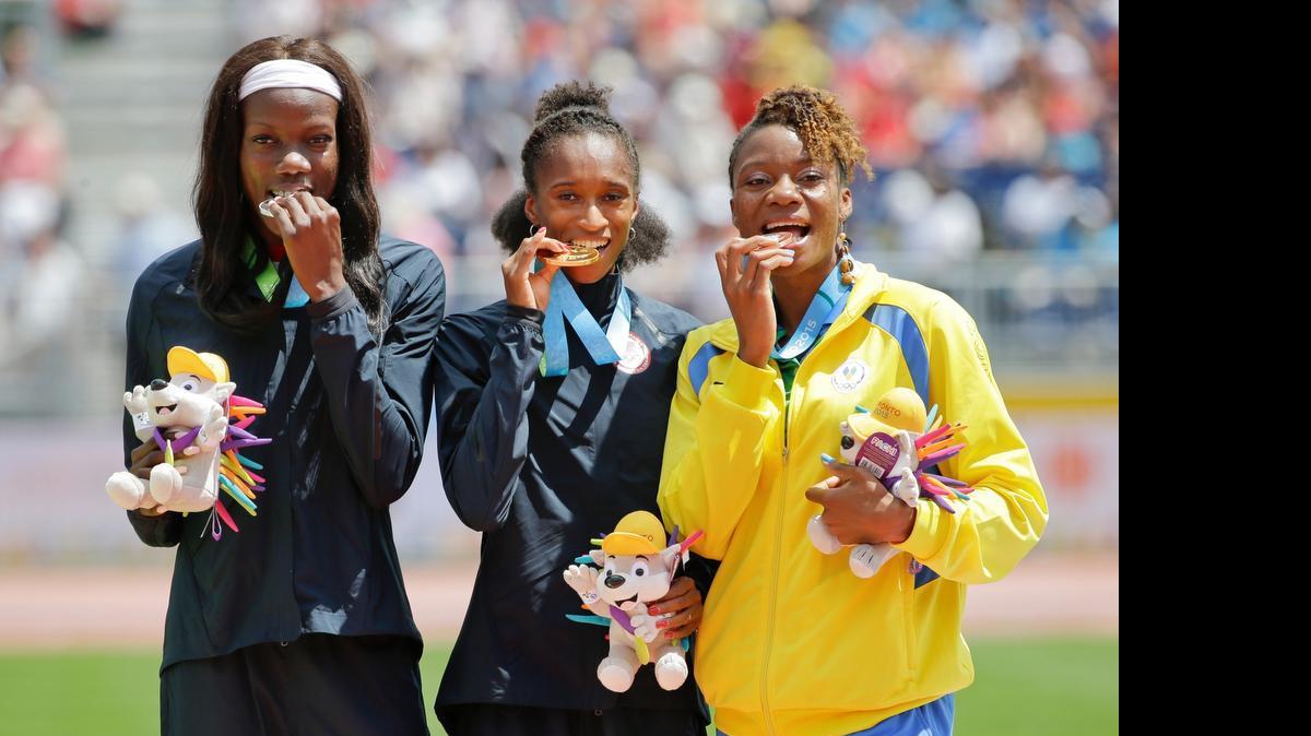 
University of Miami sprinter Shakima Wimbley, left, poses with U.S. teammate and gold medalist Kendall Baisden, center, and bronze medalist Kineke Alexander of St. Vincent and the Grenadines during the medal ceremony for the women's 400 meter race at the Pan Am Games on Friday, July 24, 2015, in Toronto. Wimbley was the silver medalist.
