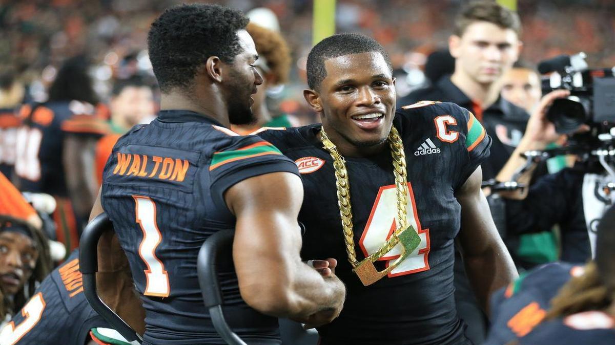 Miami Hurricanes running back Mark Walton congratulates safety Jaquan Johnson for receiving the turnover chain against Virginia Tech at Hard Rock Stadium on Saturday, November 4, 2017.