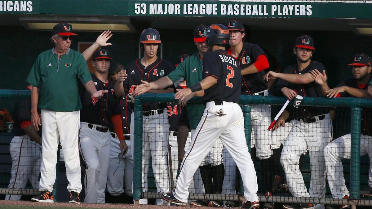 Miami Hurricanes shortstop Randy Batista is congratulated by head coach Jim Morris after scoring against FIU on April 26, 2017 in Coral Gables.