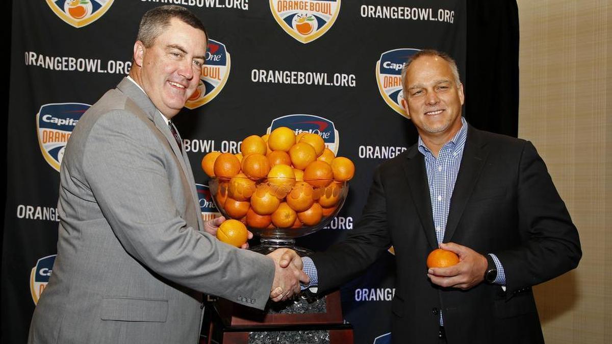 Wisconsin head coach Paul Chryst, left, and Miami head coach Mark Richt shake hands at an NCAA football news conference in Fort Lauderdale on Friday, Dec. 29, 2017. The teams will meet in the Orange Bowl on Saturday, Dec. 30.