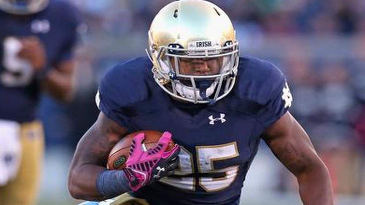 
Tarean Folston #25 of Notre Dame breaks away from Justin Thomason #98 of North Carolina at Notre Dame Stadium on Oct. 11, 2014 in South Bend, Indiana.
