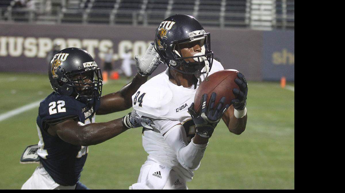 
Walk-on wide receiver Shawn Abrams catches a touchdown pass as defensive back Mark Bruno defends during FIU’s spring football game Friday, April 17, 2015 at Ocean Bank Stadium.
